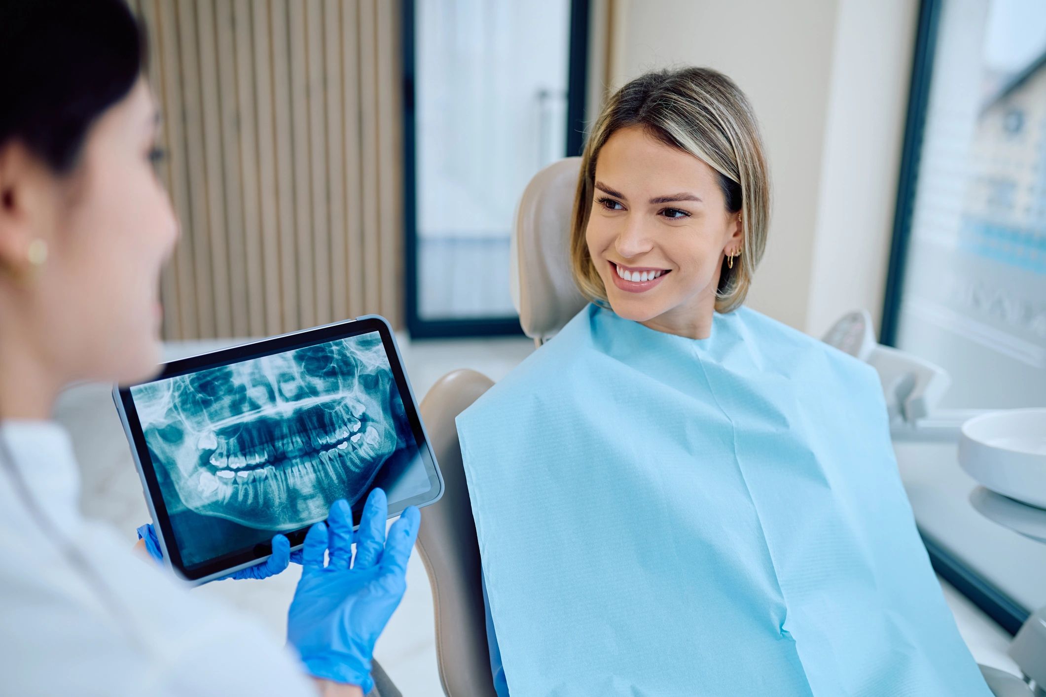 Orthodontic professional reviewing dental imaging with a patient in clinic